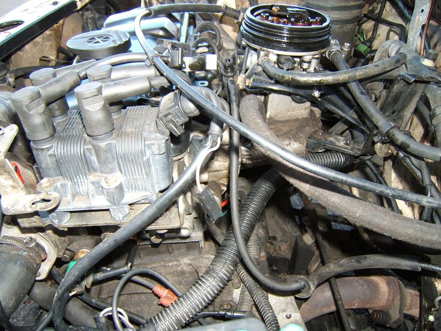 na pierwszym planie podwóna cewka zapłonowa , pod nią dekielek zaślepka na wałek rozżądu po aparacie zapłonowym