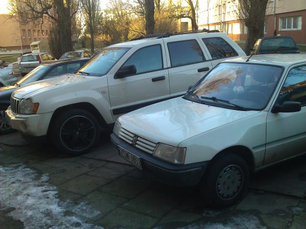 Na tle jakiegoś brzydkiego jeepa.